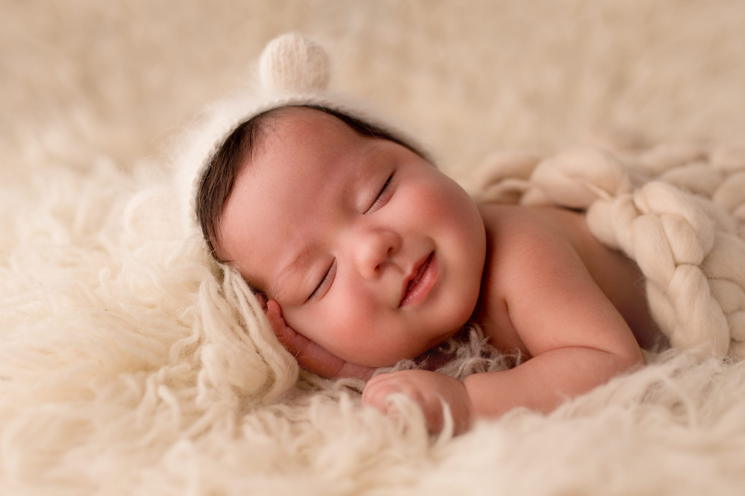 Newborn baby boy sleeping with a smile on his face